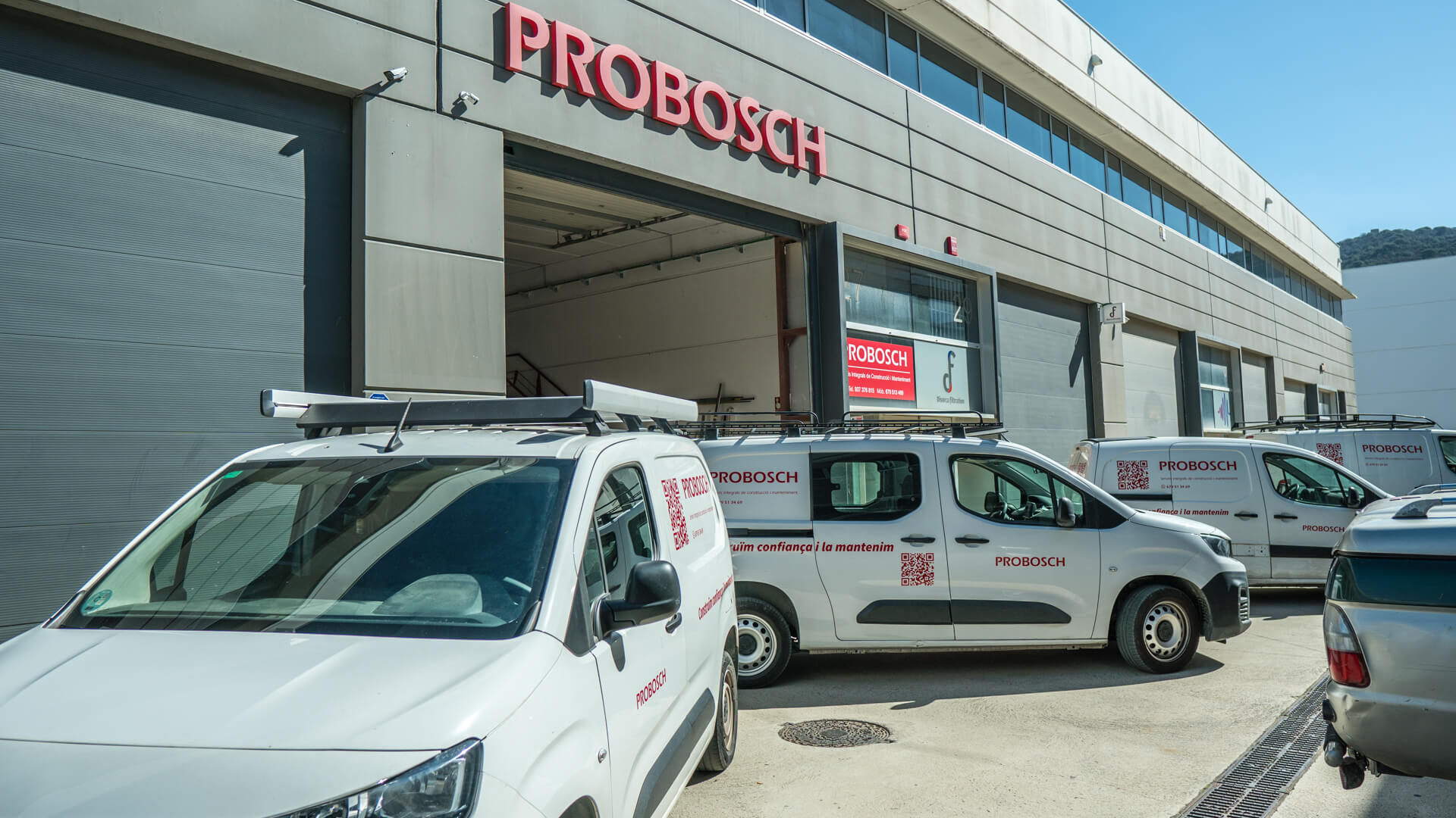 Fotografía de los vehículos de empresa saliendo del garaje del local